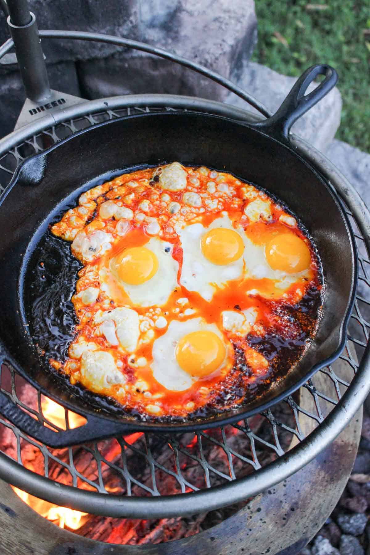 chili oil fried eggs in a skillet on the grill