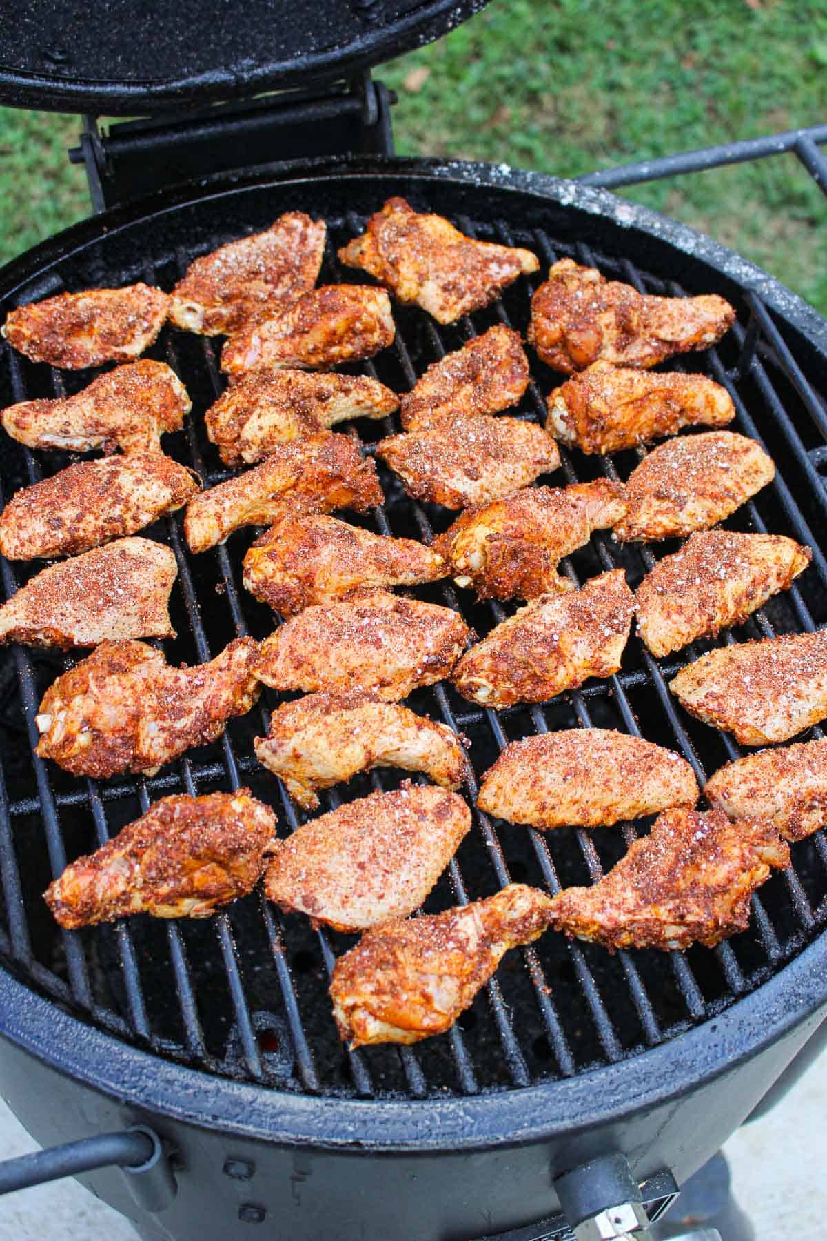 seasoned chicken wings lined on a smoker