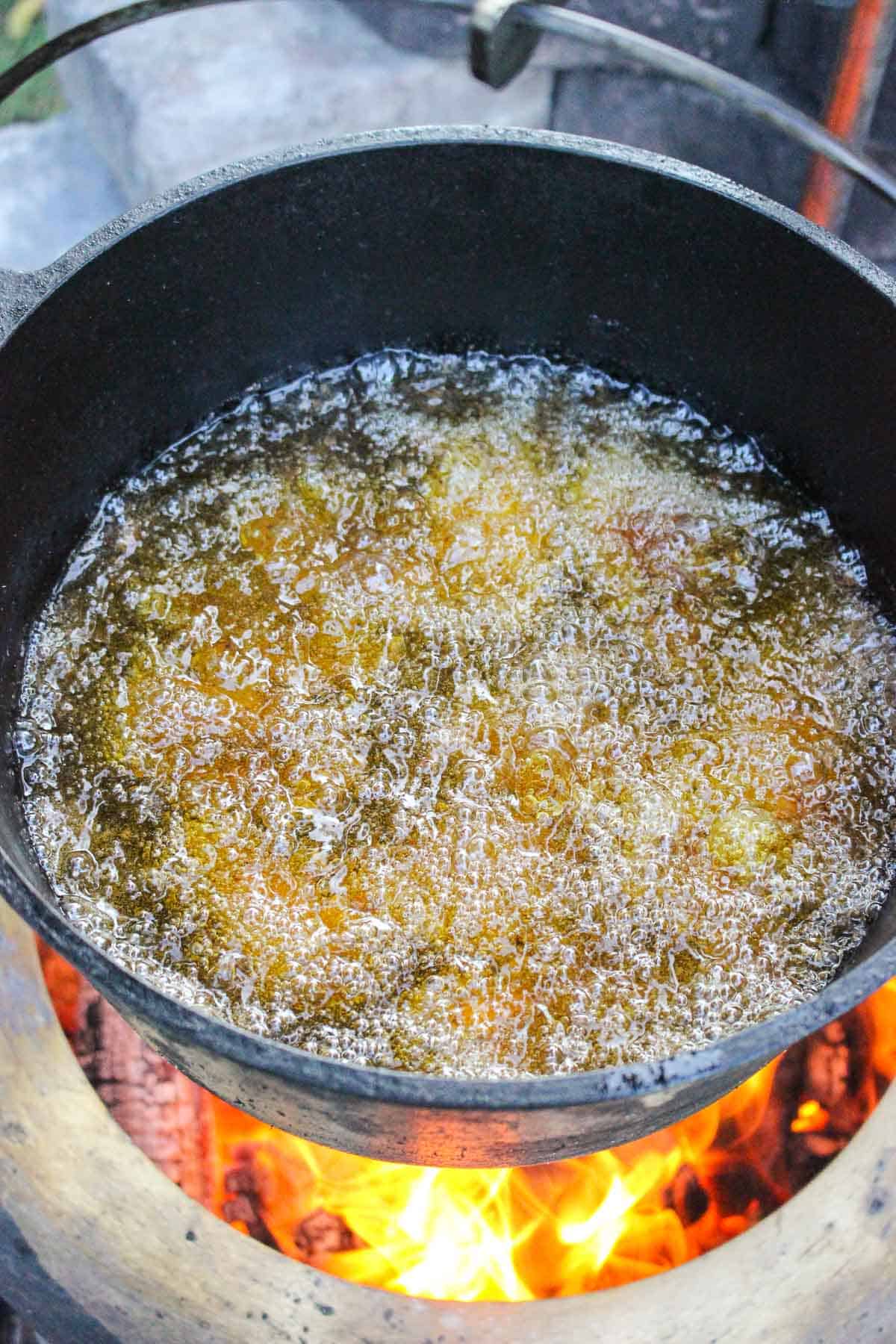 chicken wings being fried in a pot of hot oil