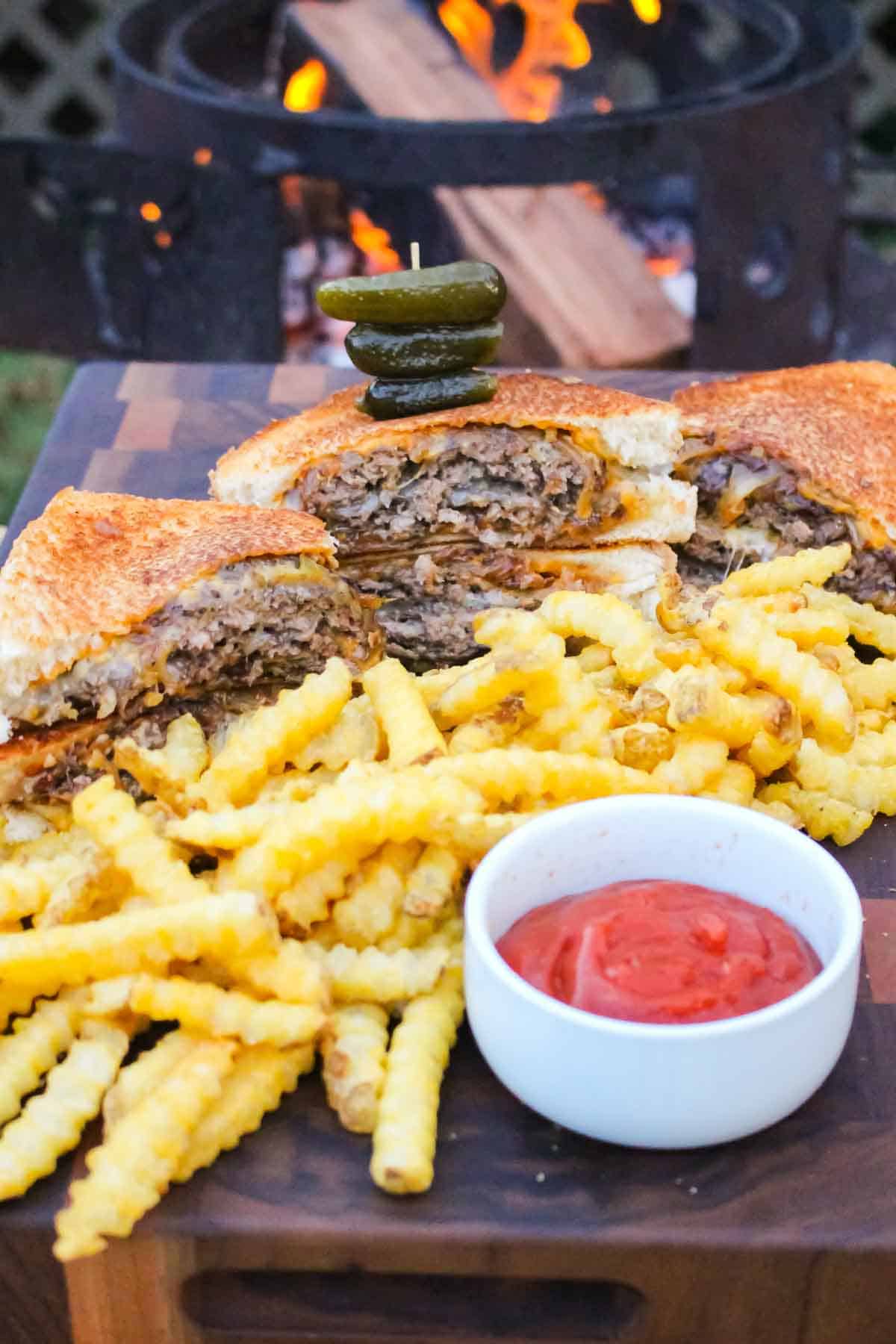 The French Onion Patty Melts Plated with fries on a cutting board.