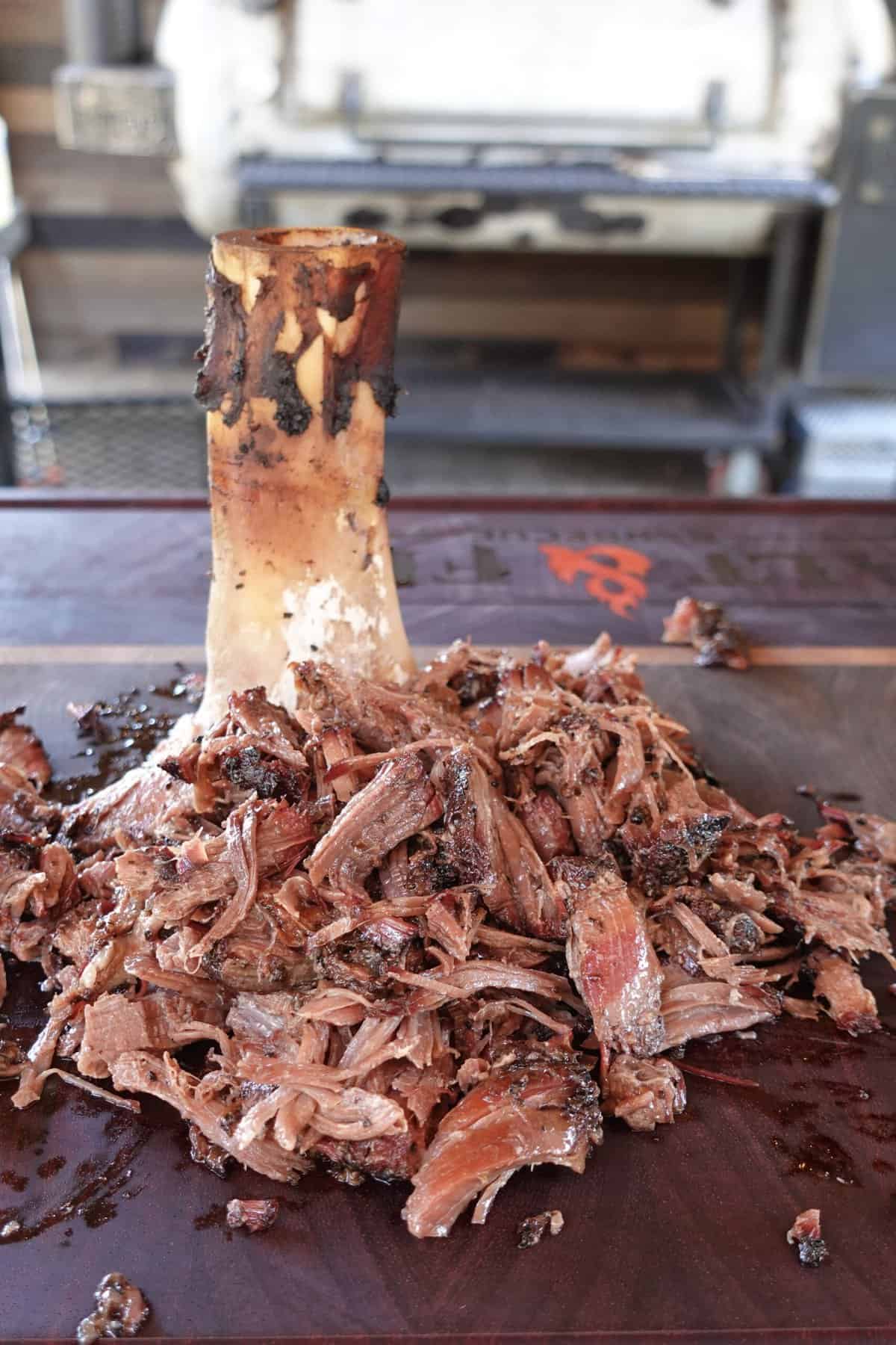 Shredded beef shank sitting on a cutting board.