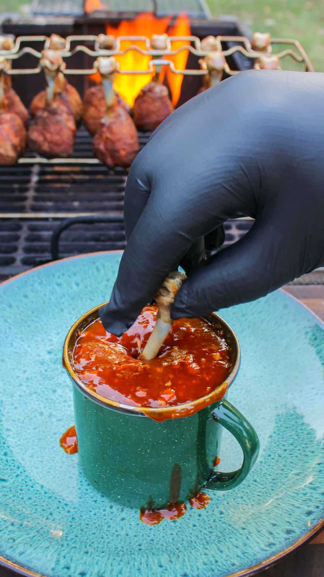 The lollipop being dunked into the garlic buffalo sauce.