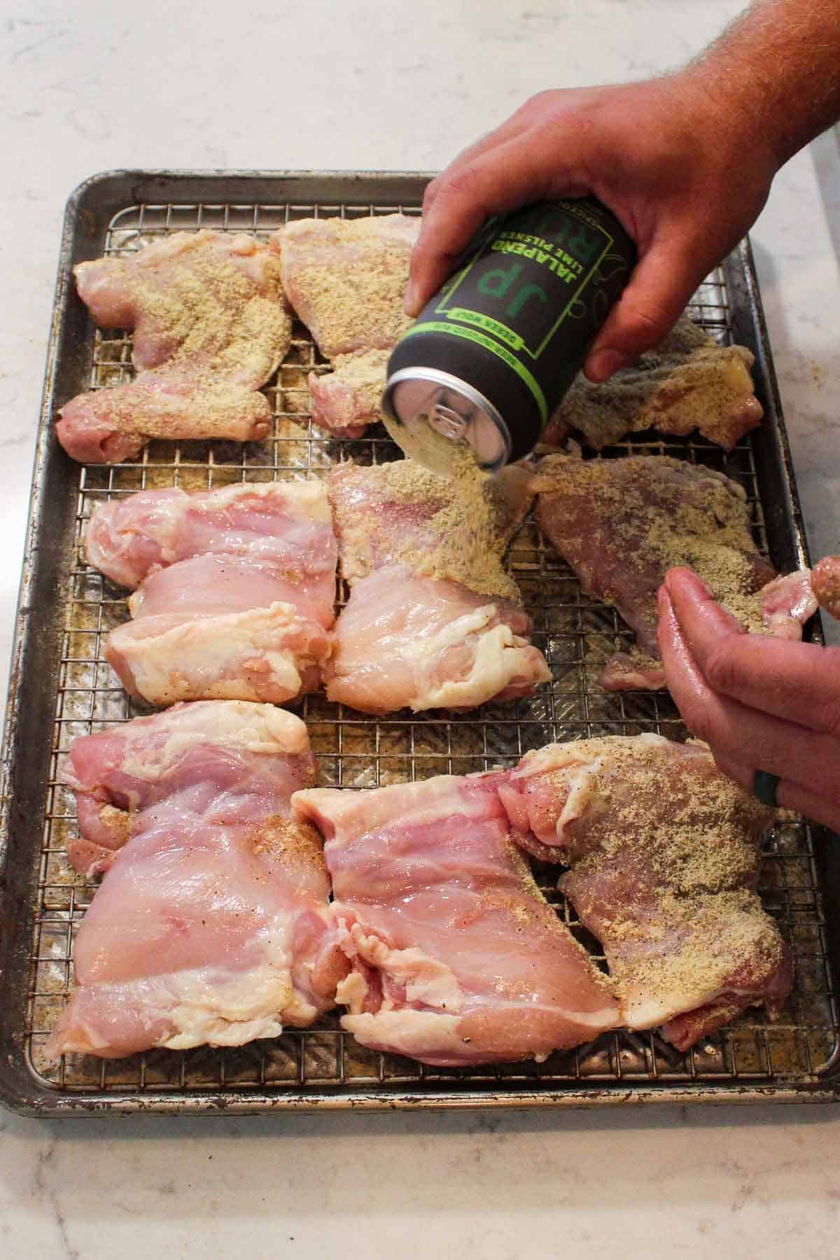 Seasoning the raw chicken with Jalapeño Lime Pilsner Rub.