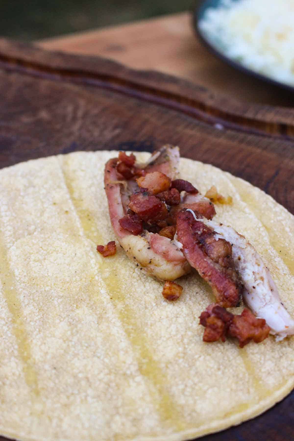 Filling the tortilla with chicken and bacon.
