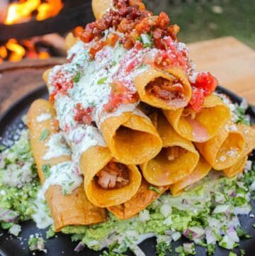 The taquitos sitting on the serving plate.