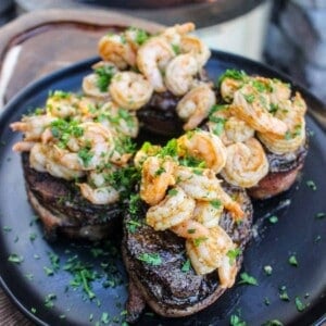 A plated shot of Bacon Wrapped Filet Mignon with Garlic Shrimp.