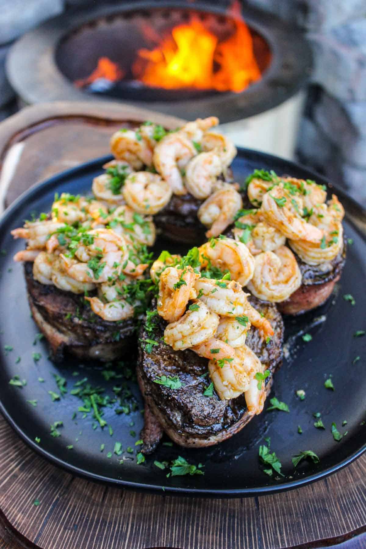 A plated shot of Bacon Wrapped Filet Mignon with Garlic Shrimp.