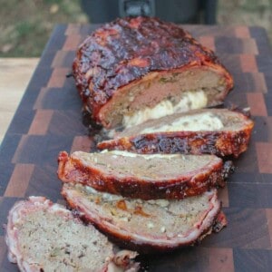 Cheese Stuffed Smoke Meatloaf sliced and sitting on a cutting board.