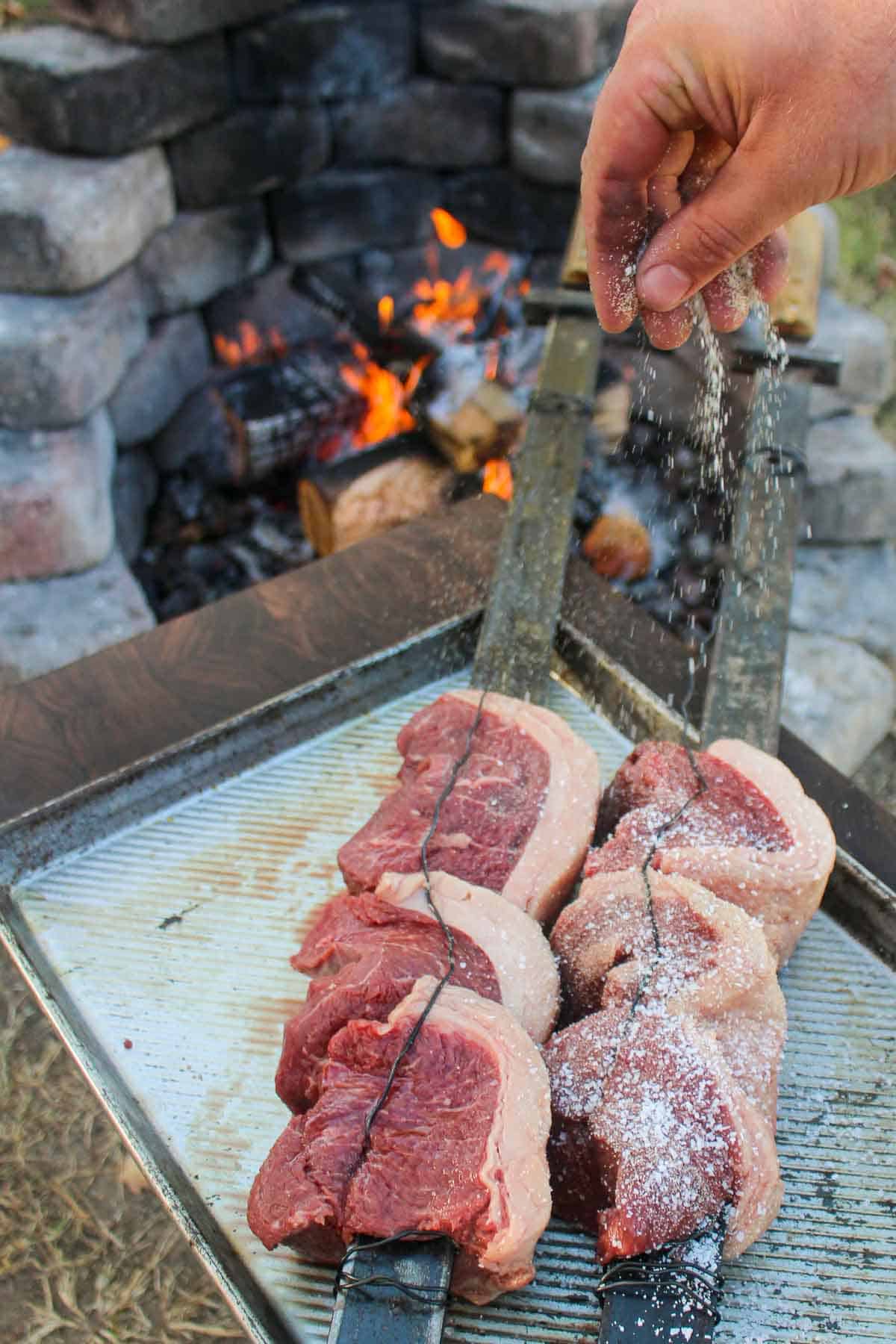 The secured skewered picanha getting seasoned.