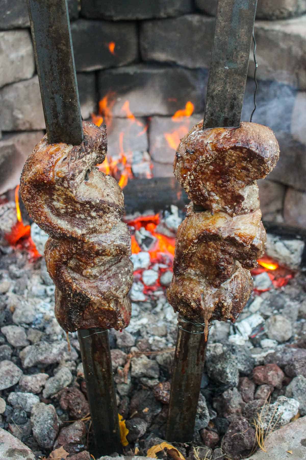 The picanha's almost finished cooking next to the fire.