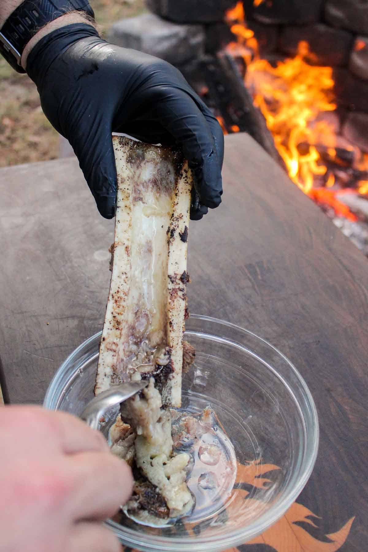 Spooning the melty bone marrow into a bowl to make the chimichurri.