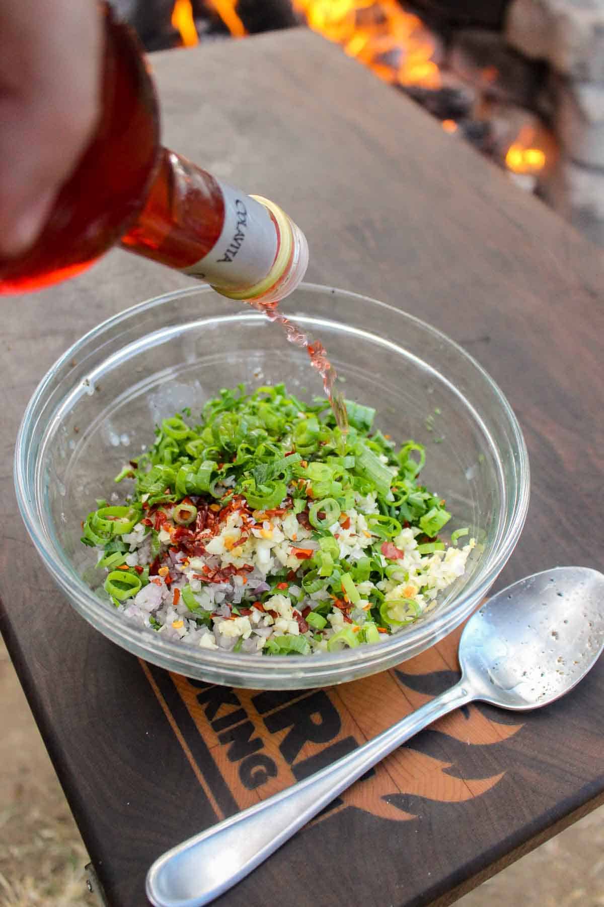 Adding red wine vinegar to the bone marrow Chimichurri.