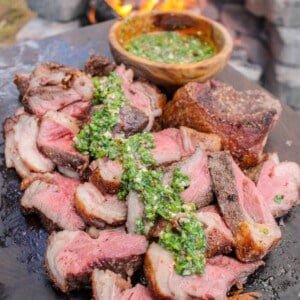 Skewered Picanha with Bone Marrow Chimichurri served on a cutting board.