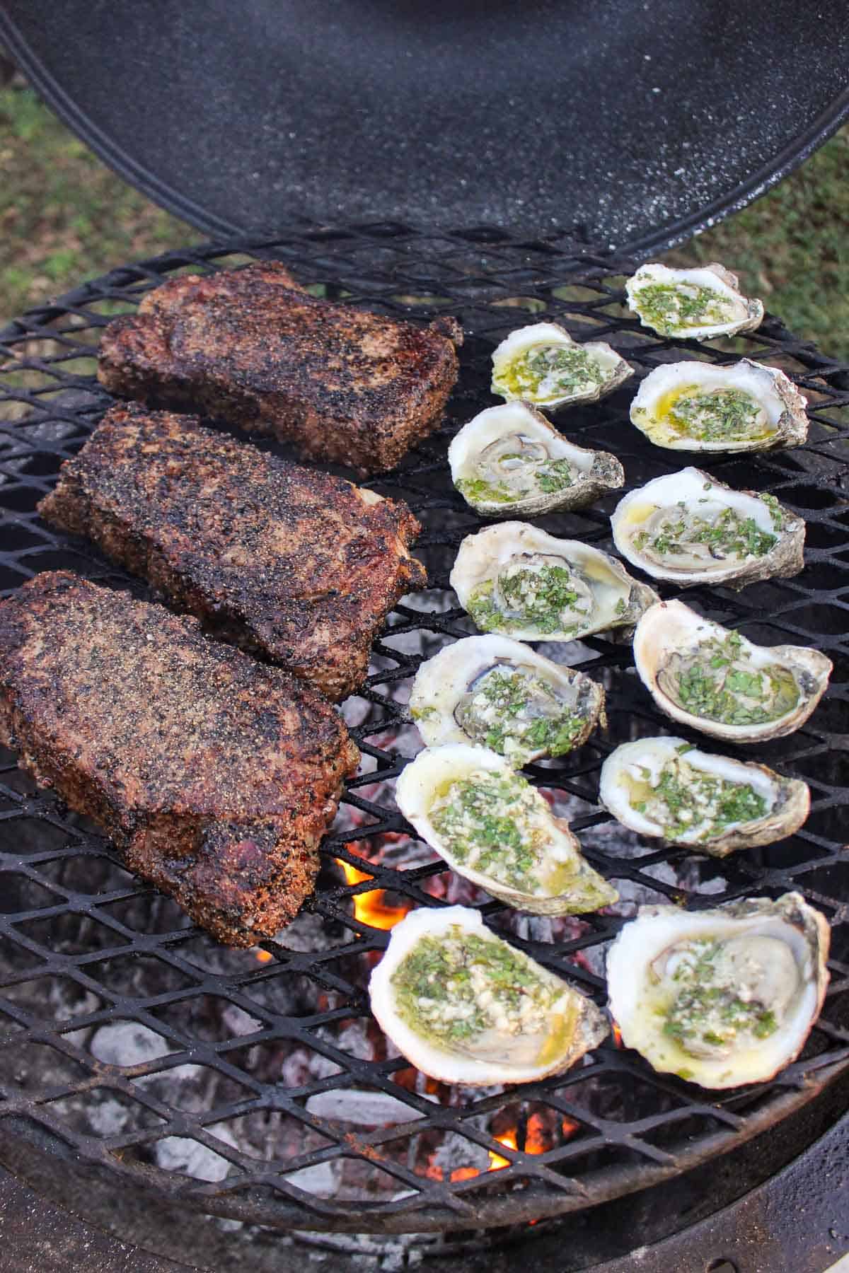 The grilled steak and oysters cooking over the fire.