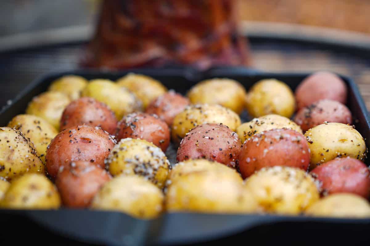 The seasoned potatoes on the grill cooking.