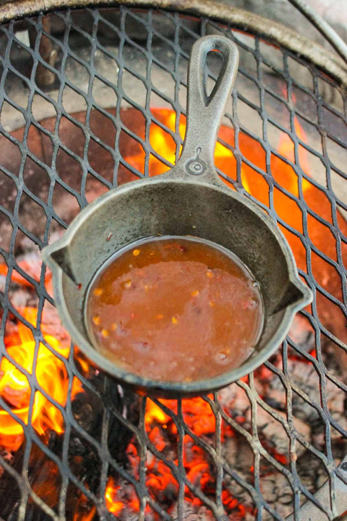 The hot honey butter simmering together in a skillet on a grill.