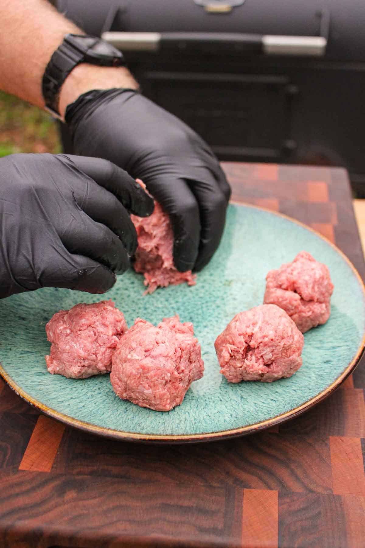 Forming the ground beef into small, round balls.