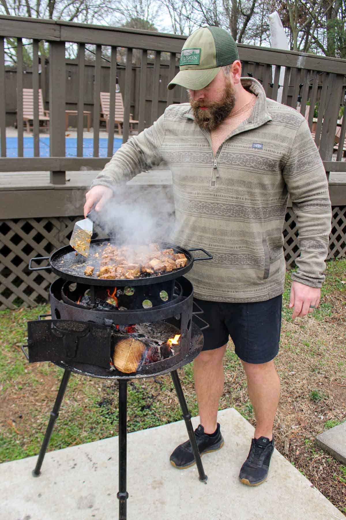 Derek grilling the steak bites on the plancha.