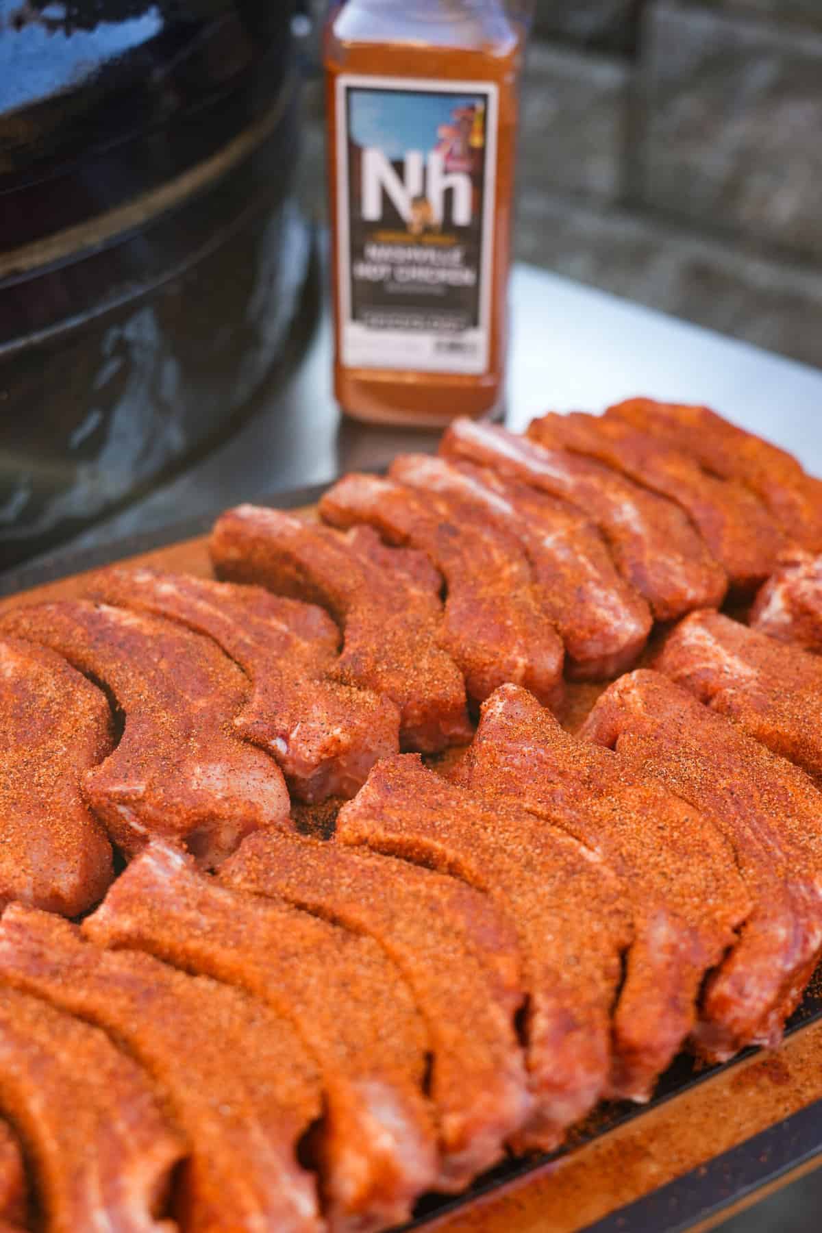 Nashville Hot rub sitting with the raw seasoned ribs on a cutting board.