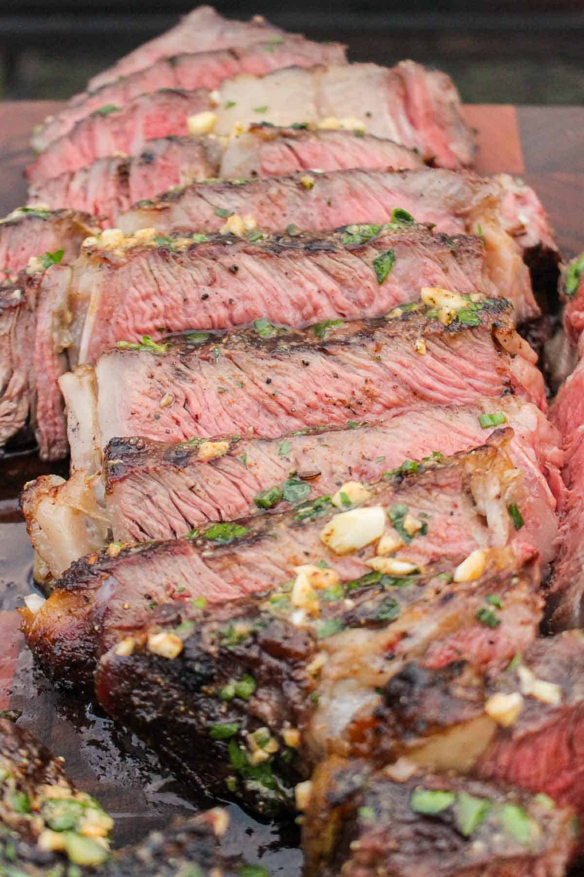 A close up of the sliced grilled ribeye with cowboy butter.