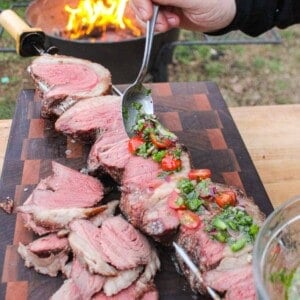 Adding the fresh salsa to the top of the sliced rotisserie picanha with parmesan crust.