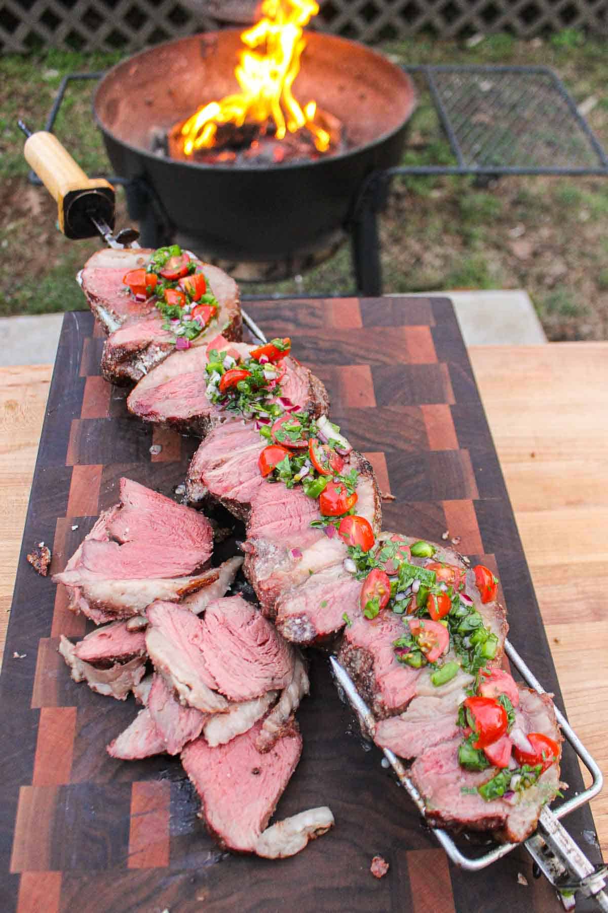 One final shot of the picanha being served topped with the fresh salsa.
