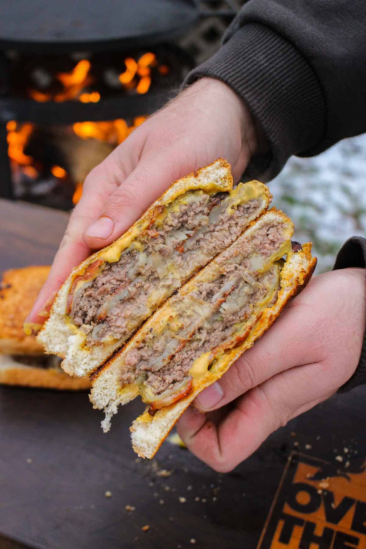 Holding one of the sliced Oklahoma Onion Patty Melts close up to the camera.