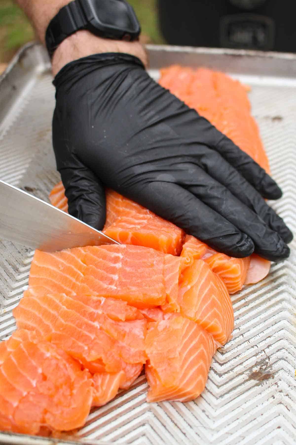 Cutting the salmon filet into bite size pieces.