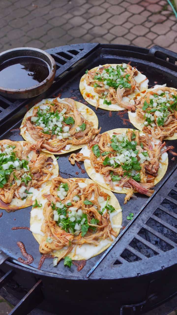 The al pastor pork belly tacos in their final cooking stages on the grill.
