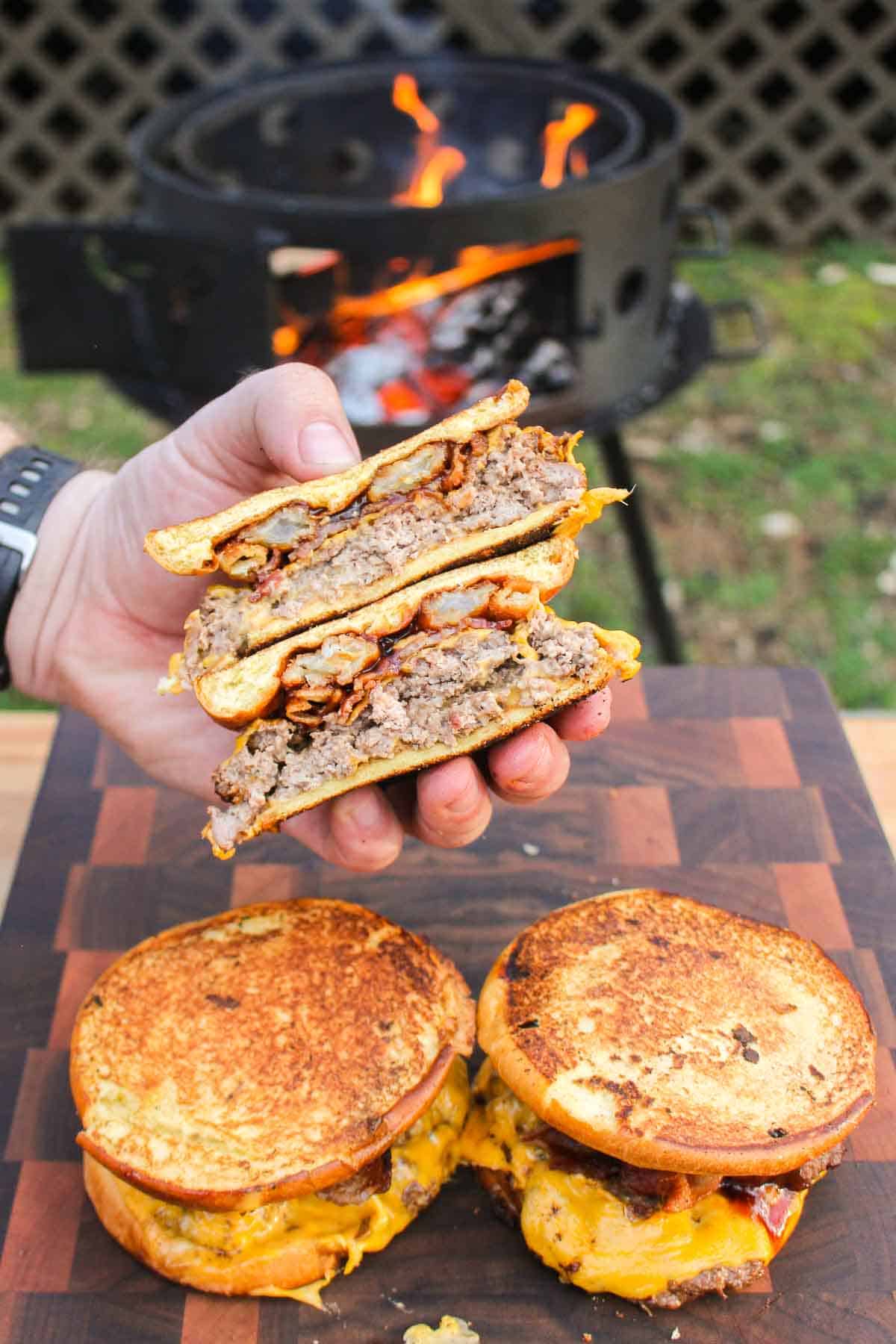 Holding a sliced Grilled Cheese BBQ Cheeseburger up to the camera.