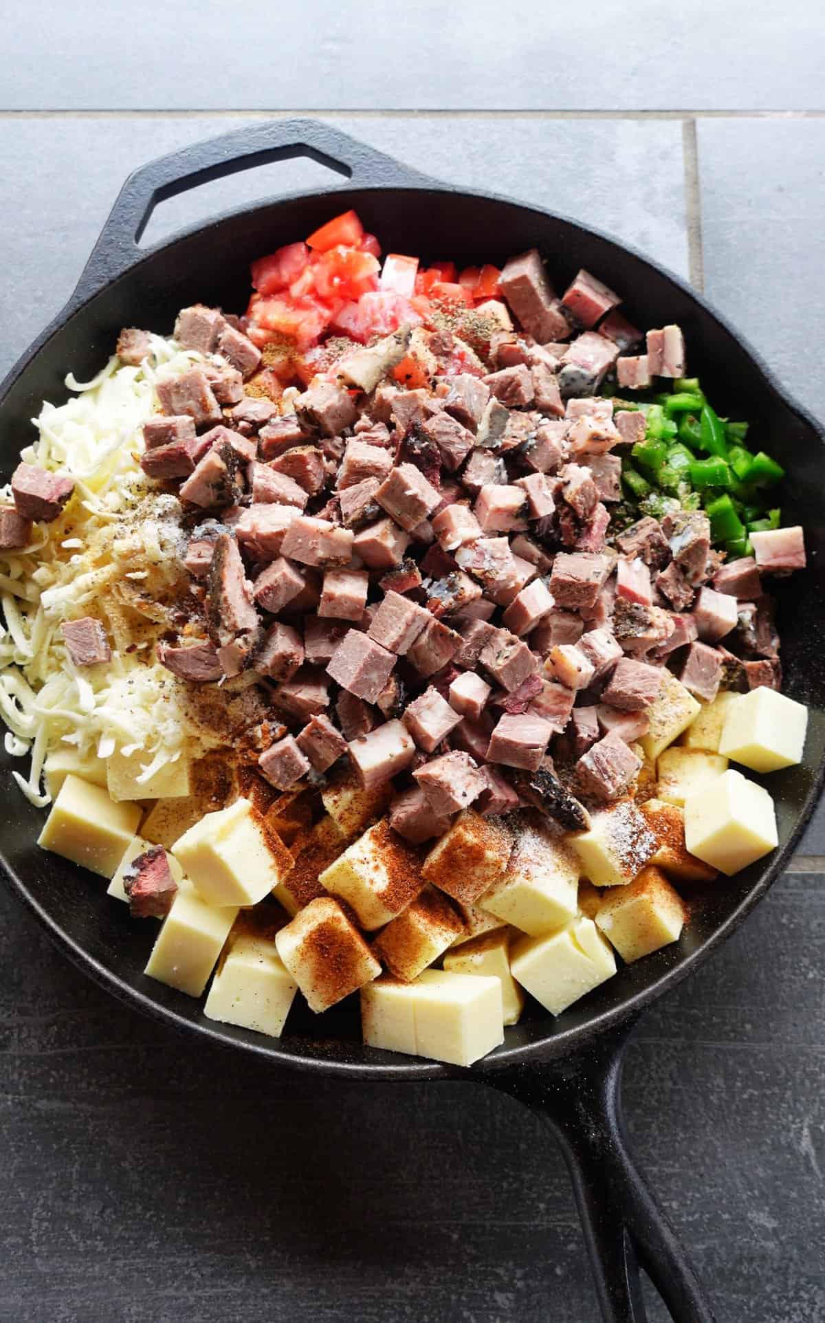 All the smoked brisket queso ingredients sitting in the skillet.