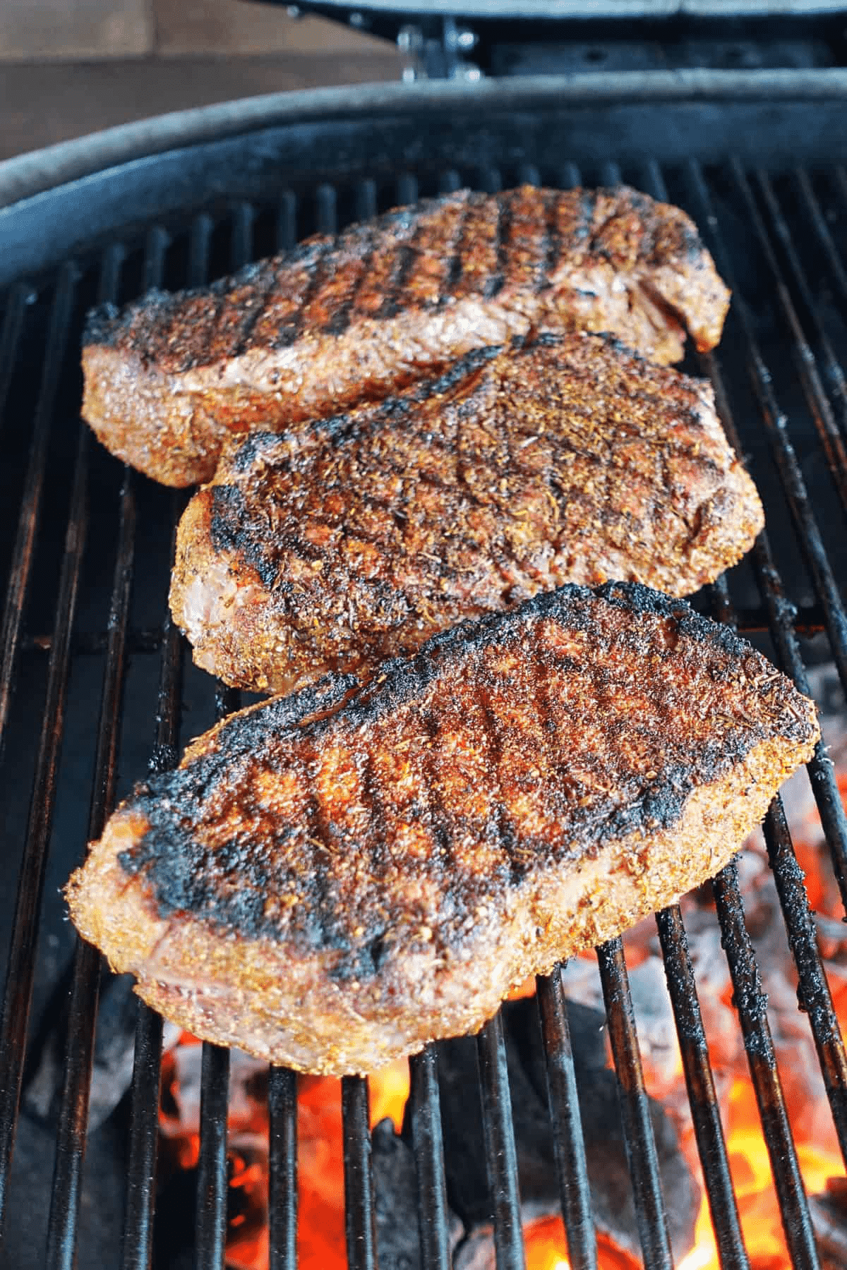 Steaks searing over high heat.