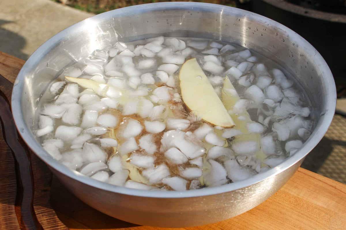 The potato wedges in a ice water bath.