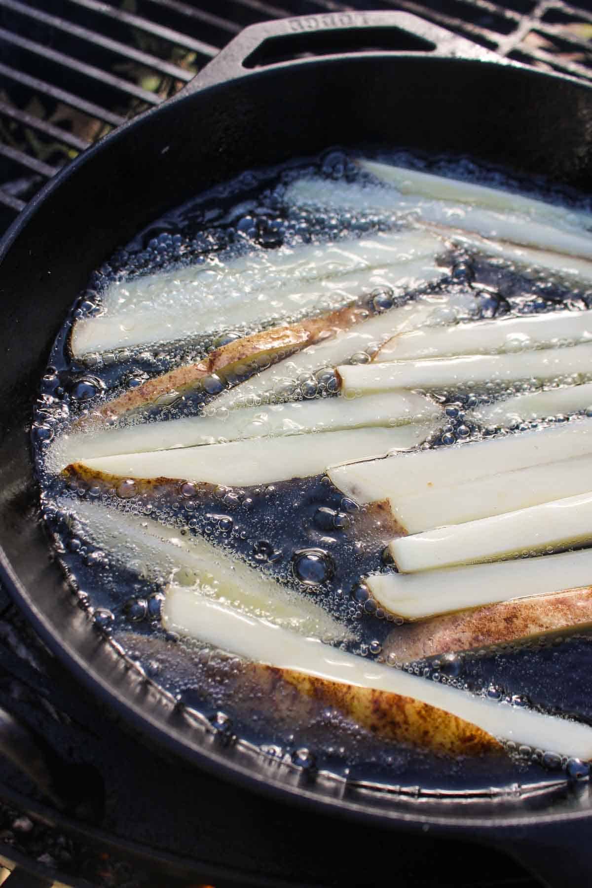 The raw potatoes getting placed in the frying oil.