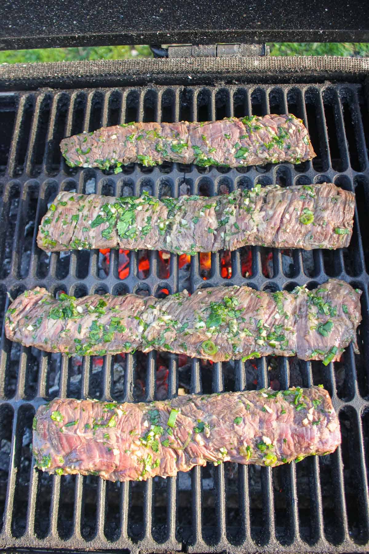 Adding the raw steaks to the grill.