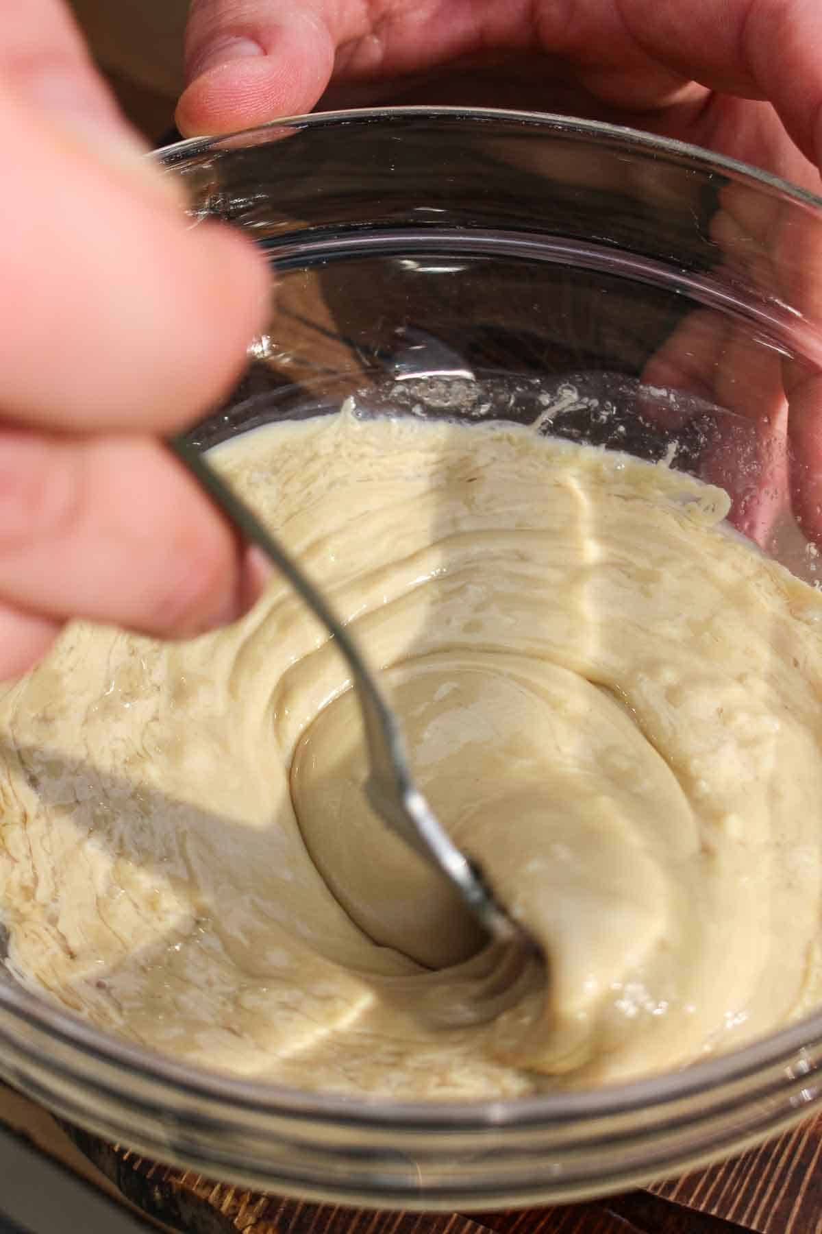 The tahini sauce being mixed together before being set to the side.