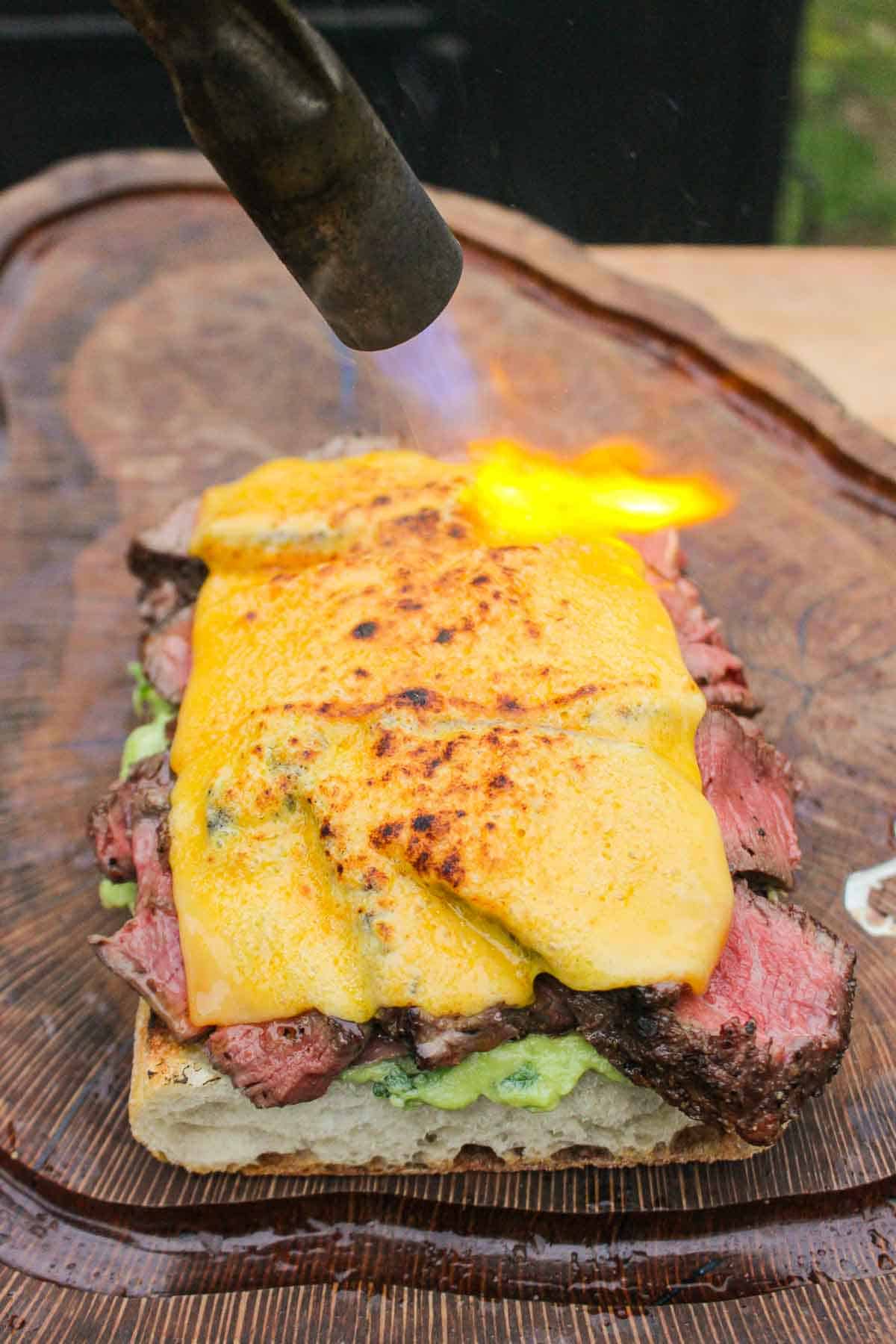 Melting the cheese on top of the steak as we assemble the sandwich.