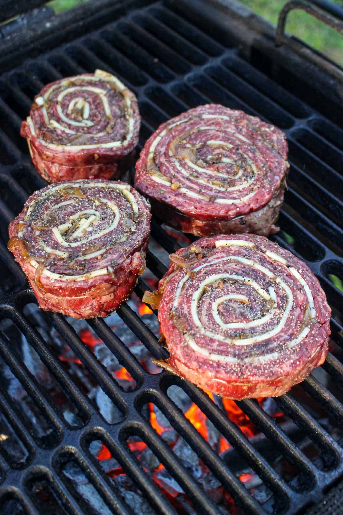 Adding the French Onion Steak Pinwheels to the grill to sear.