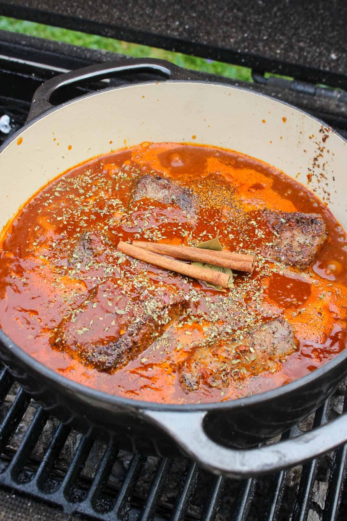 Adding the chili paste to the dutch oven so the short ribs can braise in it.