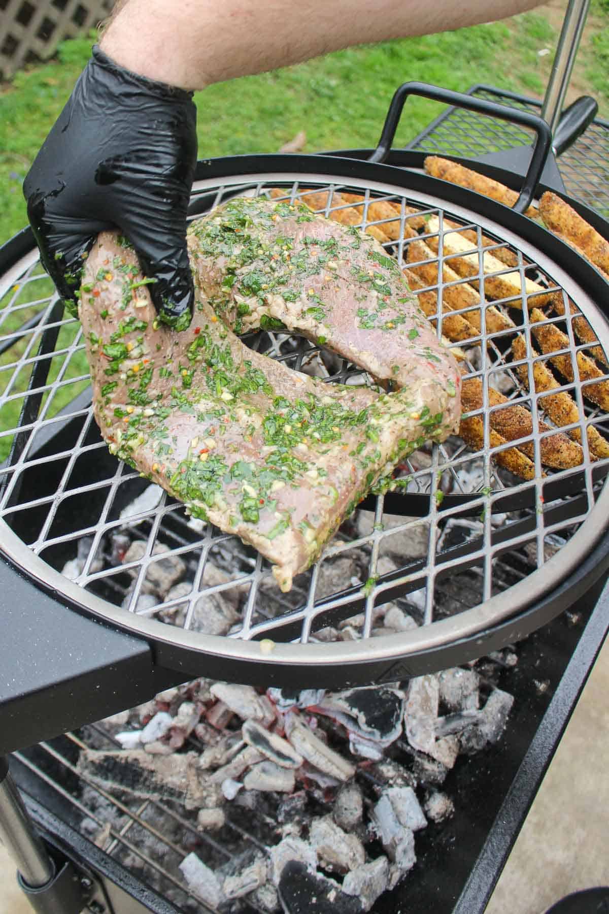 Adding the Chimichurri Marinated Tri-Tips to the grill.