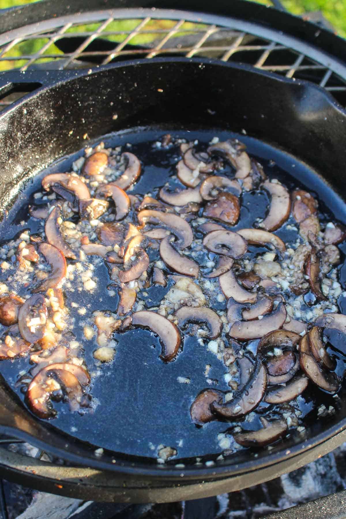 The mushrooms on the grill getting mixed together so we can begin to form the cream sauce.