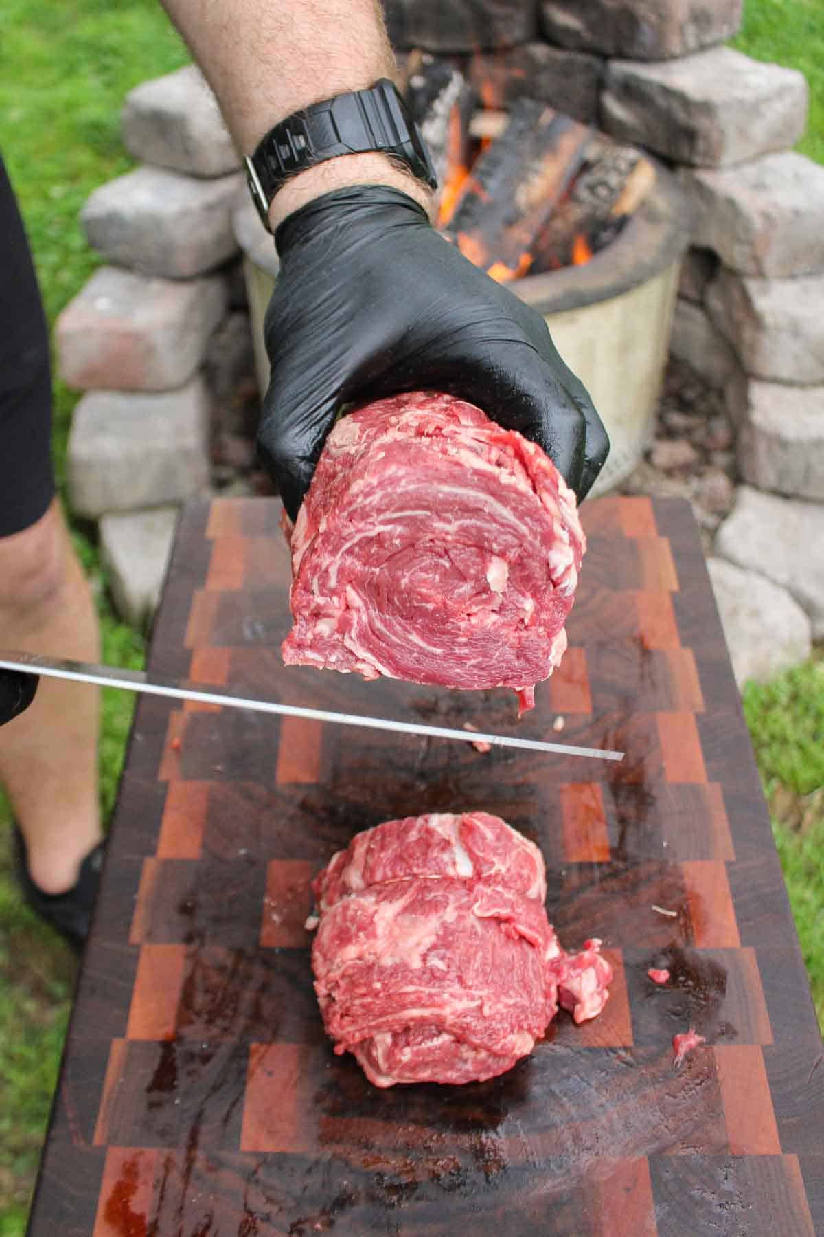 Slicing the ribeye caps into individual steaks.
