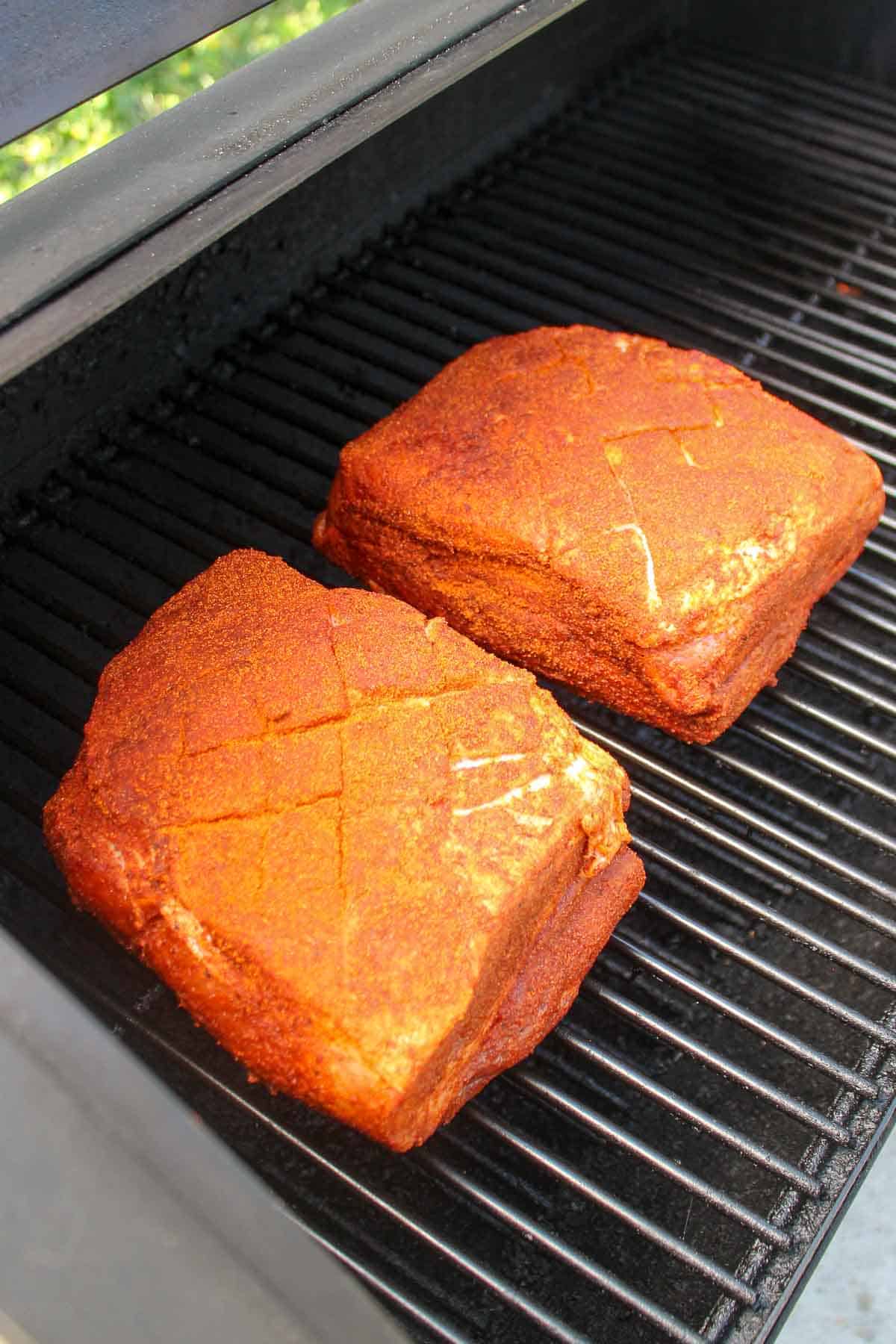 Seasoned pork butts on the smoker.
