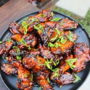 A plate full of Hot Honey Garlic Wings that are garnished and served.