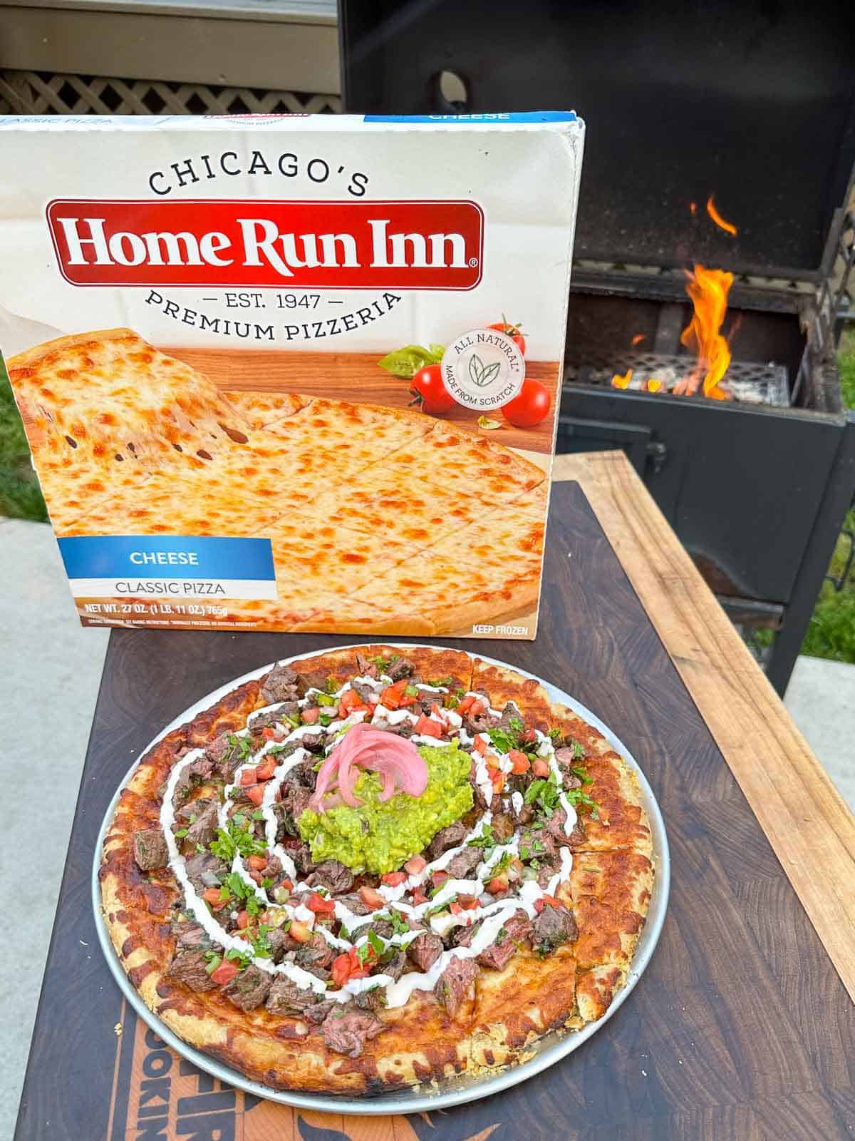 The finished carne asada pizza with a Home Run Inn box in the back so you can see what type of pizza we used.