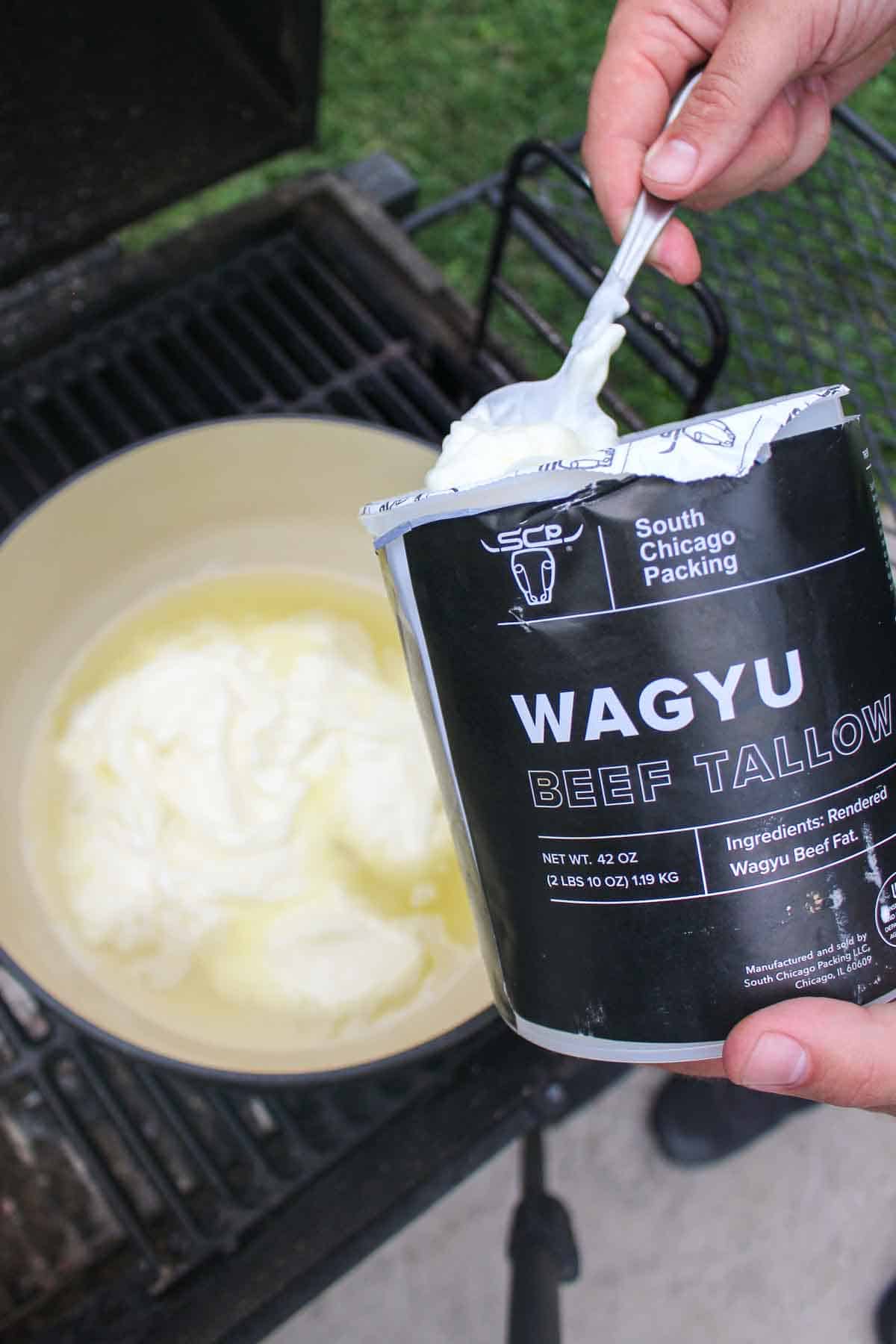 Adding South Chicago Packing's Wagyu beef tallow to the dutch oven so that it can heat up for frying. 