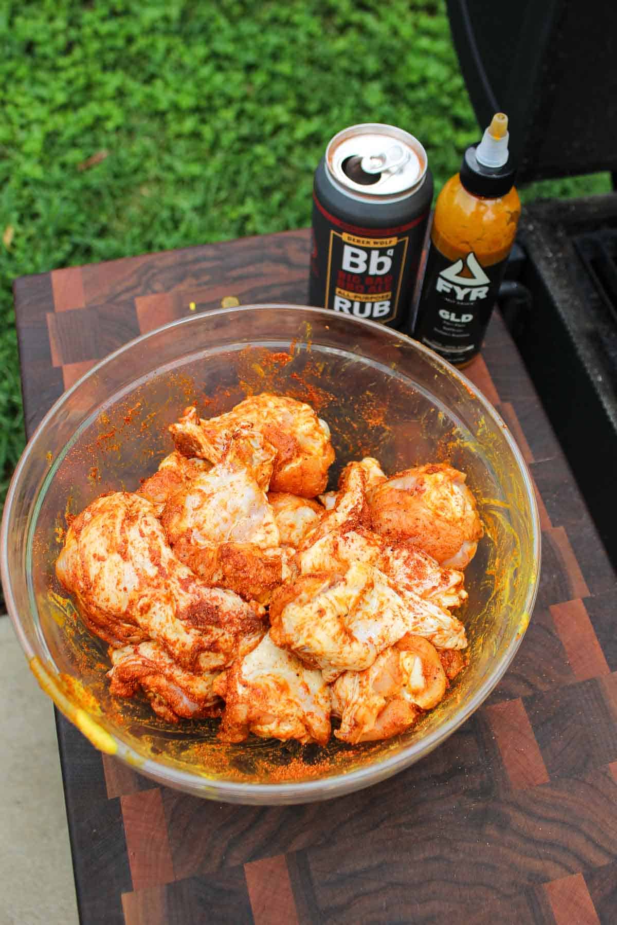 The raw wings being seasoned in a bowl before being placed on the smoker.