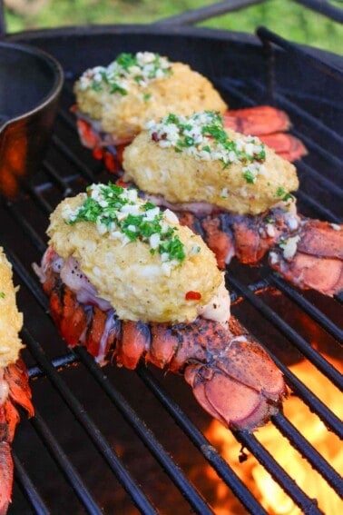 Stuffed Lobster Tails with garlic butter as they finish cooking on the grill.