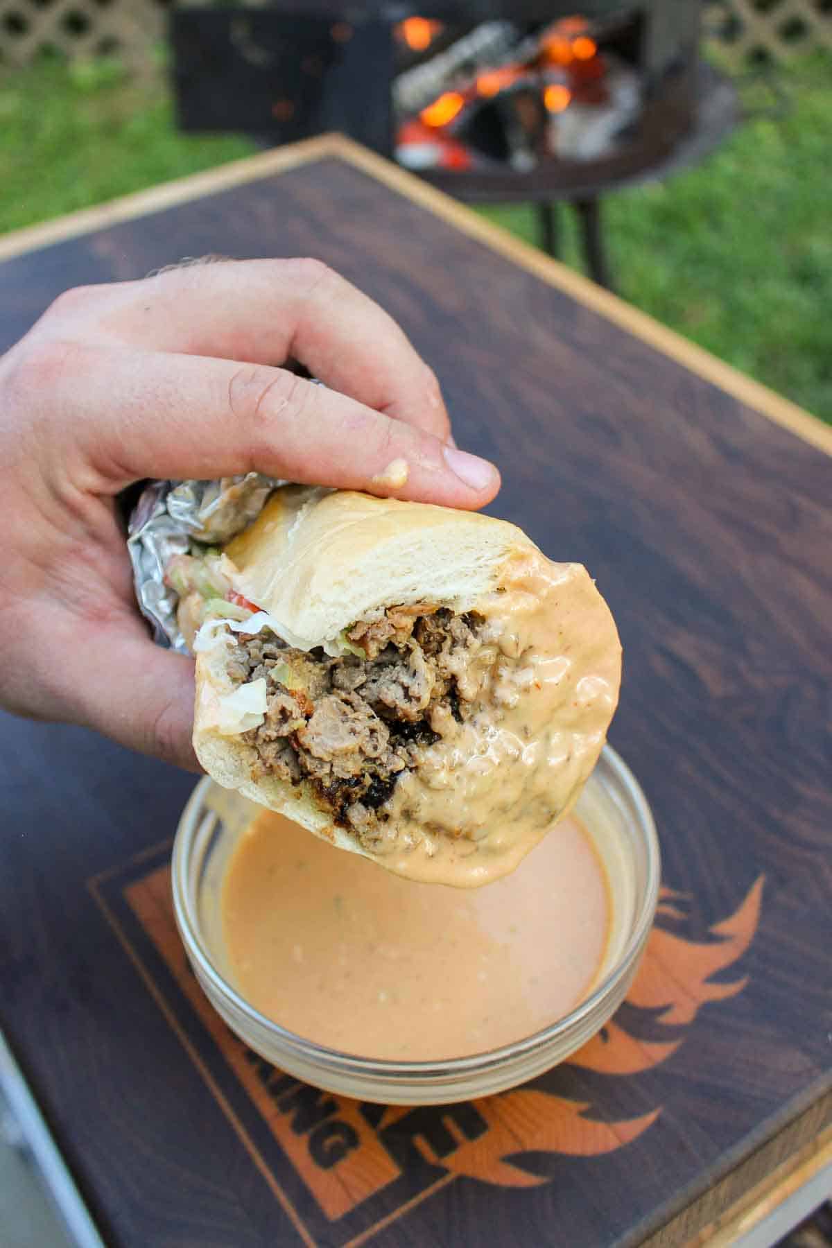 The cheesesteak after being dipped in the sauce.