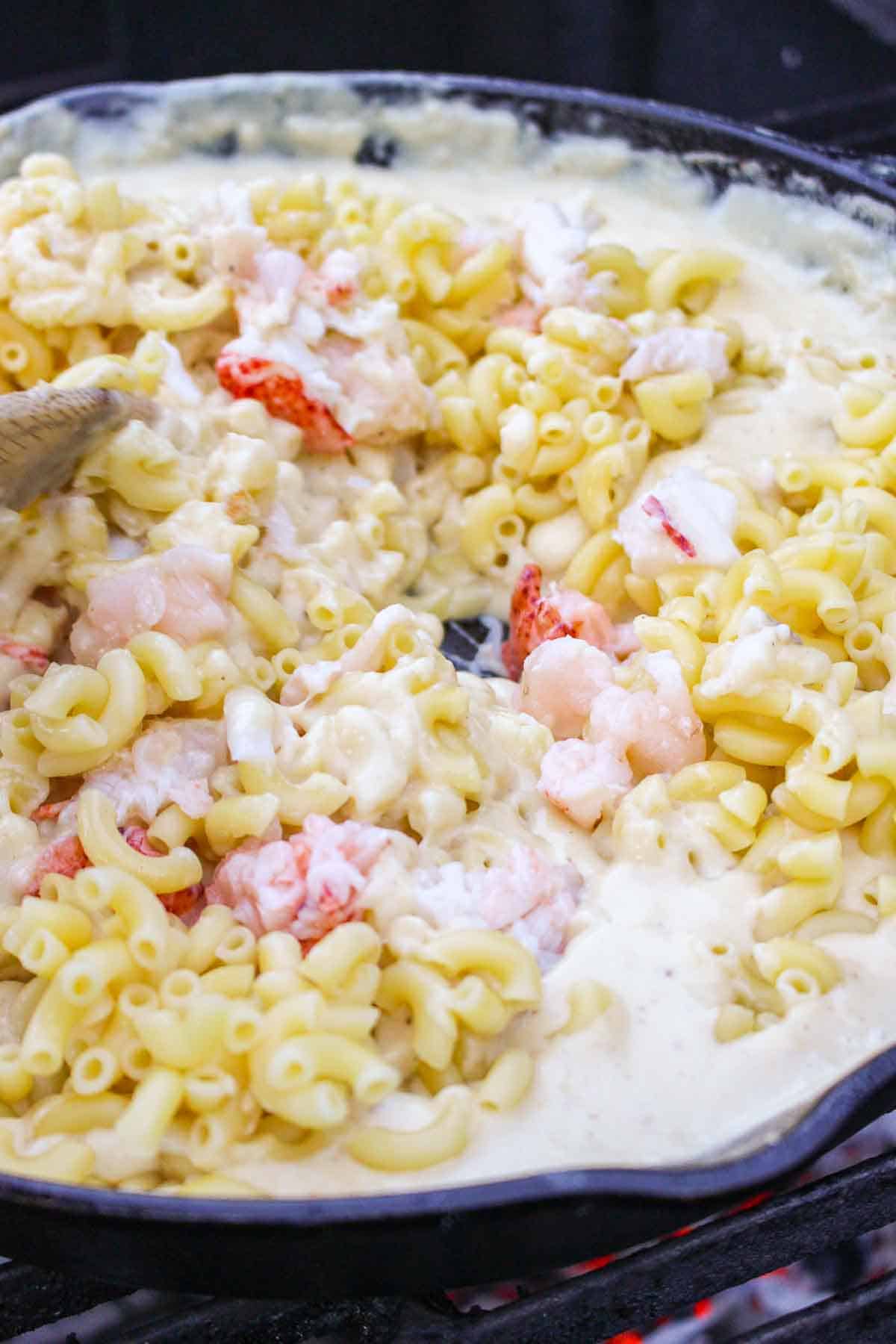 The lobster Mac and cheese getting mixed together.
